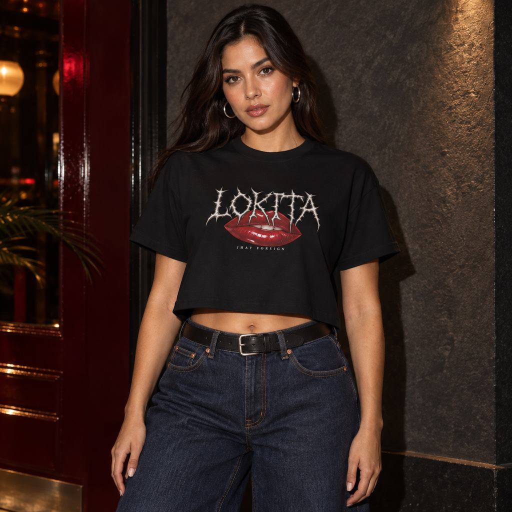 Styled model mockup of the black LOKITA Lip Bite Crop Tee with red lips, spiky lettering and Jhay Foreign signature.