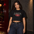 Styled model mockup of the black LOKITA Lip Bite Crop Tee with red lips, spiky lettering and Jhay Foreign signature.